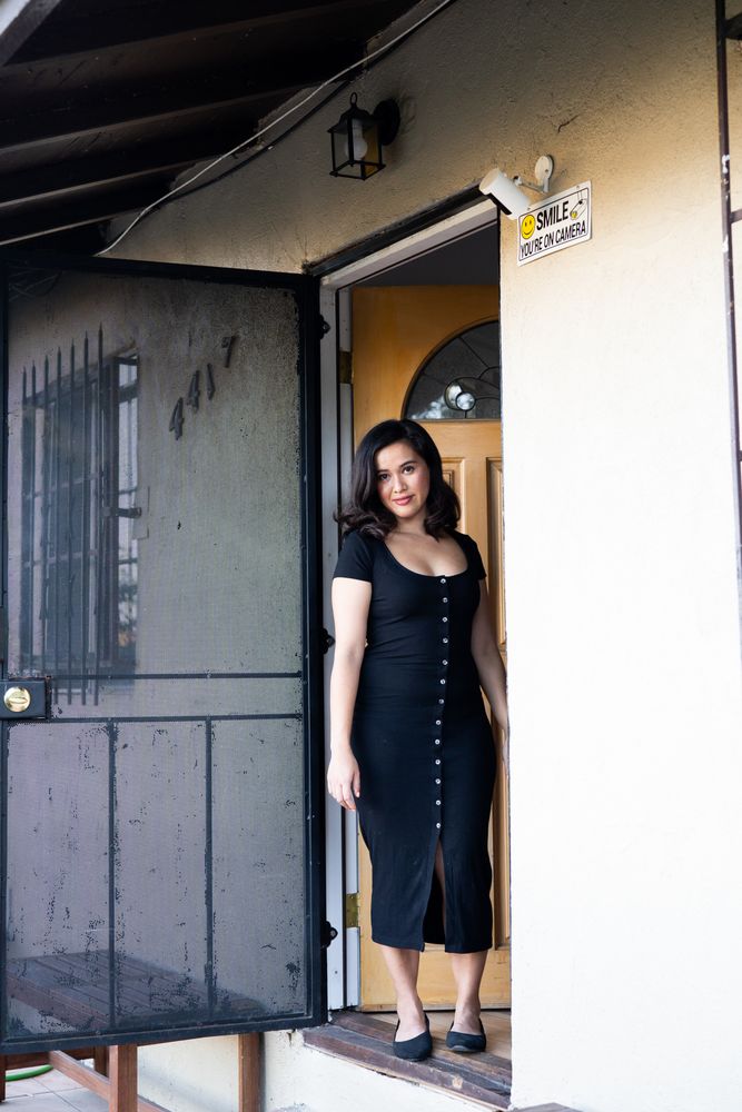 Full length portrait of woman in dark dress smiling and looking at camera