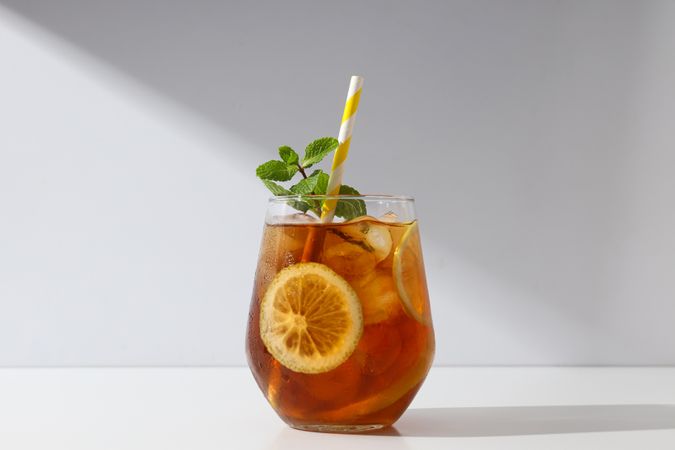 A glass of delicious cold tea on a plain background