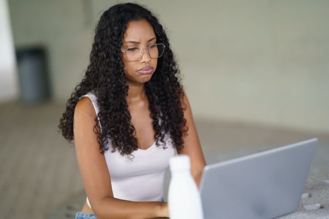 A Focused Woman is Intently Engaged in Productive Work on Her Laptop in a Modern Office Environment