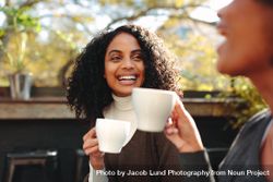 Two women laughing and having fun at a coffee shop 5RqVD0