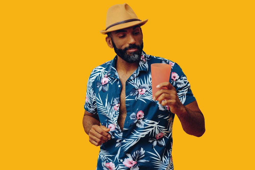 Happy male looking appreciatively at his drink in a orange cup with copy space