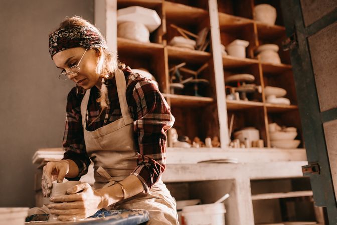 Female potter concentrating in pottery workshop
