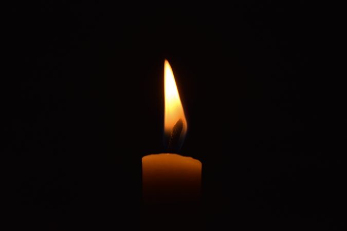 Side view of candle burning in the dark