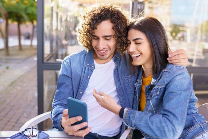 Male and female taking selfie sitting down outside