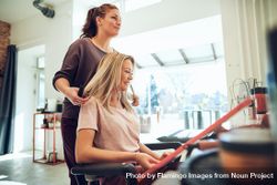 Female customer sitting in salon chair selecting hair color 5oPwy4