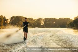 Man riding wakeboard on wave of motorboat 5rNB35