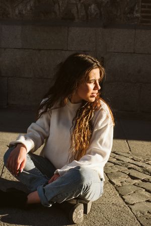 Cheerful woman sitting on pavement