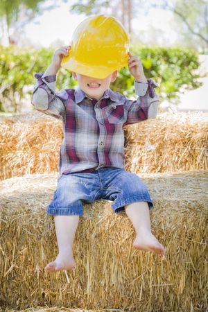 Young Biracial Boy Laughing with Hard Hat Outside