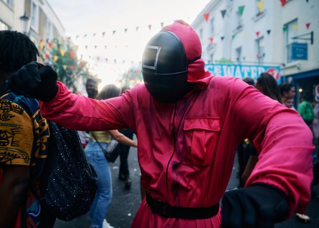 London, England, United Kingdom - August 28, 2022: Person dancing in mask and pink boiler suit