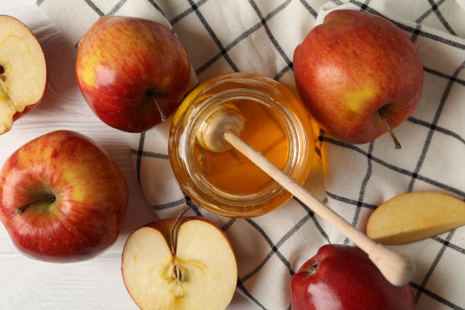 Top view of apples and honey on kitchen towel