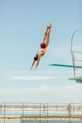 Woman diving into the pool from spring board 4jrYz4