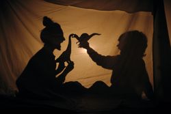 Silhouette of mother and son playing in shadow theater