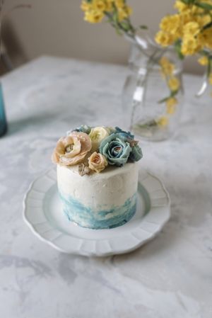 Buttercream flowers cake, blue and pastel peach colors