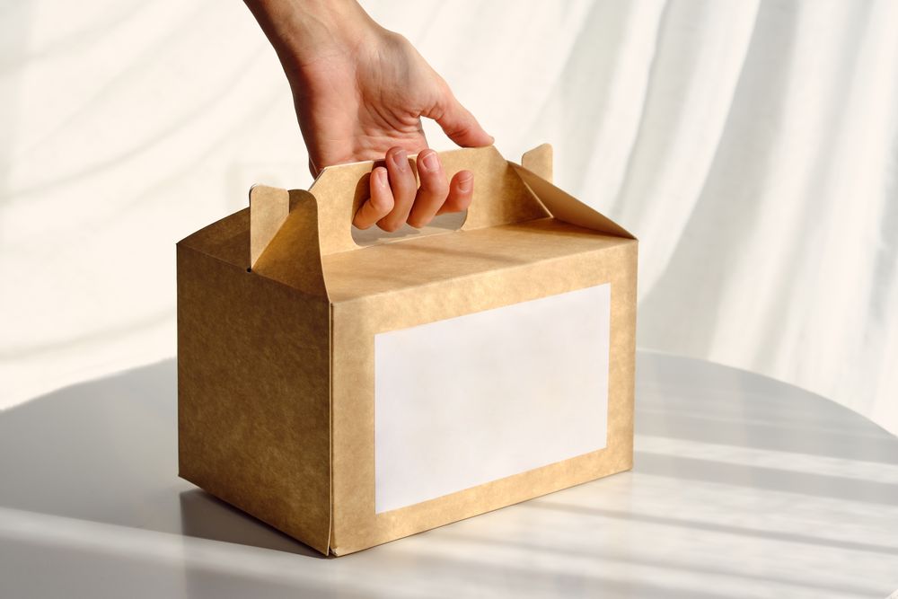 Woman taking carton box placed on table