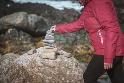 Tourist balancing stones during travel in rocks