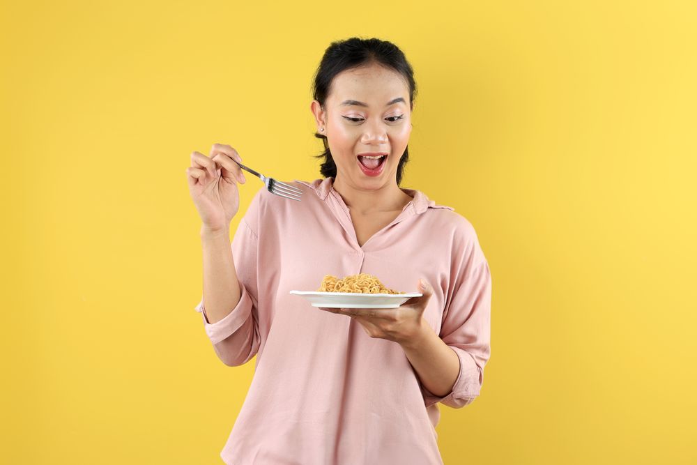 Happy Asian Woman, Using Fork Eating Instant Noodle or Mie Goreng on Plate