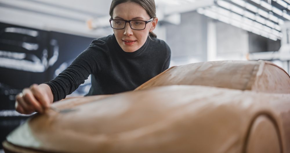 Close Up Portrait of an Automotive Designer Sculpting a 3D Clay Model of a New Production Car.