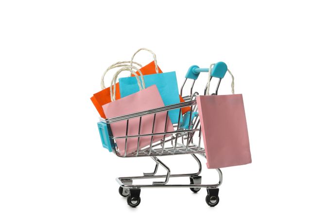 Shop cart with paper bags isolated on bright background