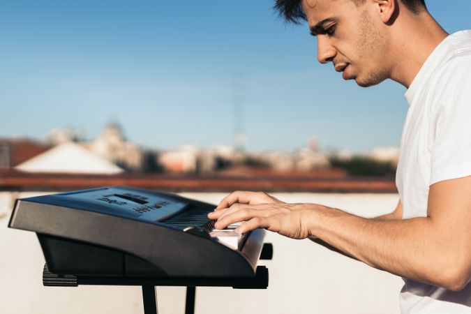 man playing piano on an urban rooftop