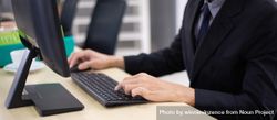 Male employee typing on computer keyboard at desk bYByg0