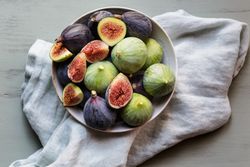 Plate of fresh ripe figs on kitchen table