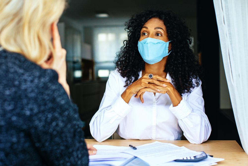 Two colleagues having a serious business discussion while wearing facemask