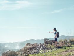 Boy with backpack exploring mountains