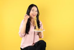 Happy Asian Woman Eating Instant Noodles.