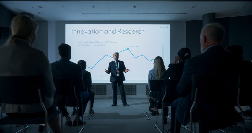 Corporate Event: Male Tech CEO Giving Presentation To Colleagues or Investors In the Conference Room Of Innovative Startup Office.