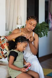 Mom combs her daughter's hair
