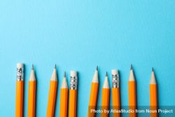 Pencils in a row on blue background with copy space 0yJ215