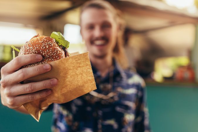 Focus on hands holding food truck burger
