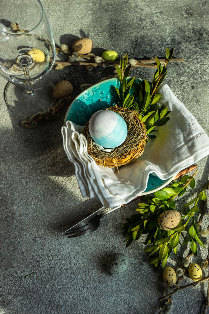 Easter table setting with blue egg in a nest on table