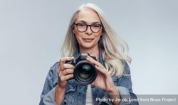Portrait of  woman standing with dslr camera 5wgg95