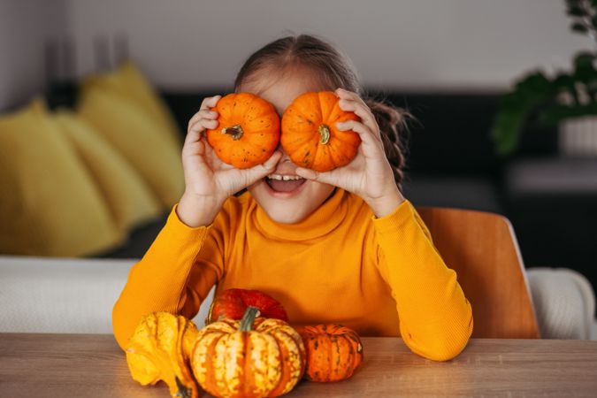 Little Girl Playing With a Pumpkin.