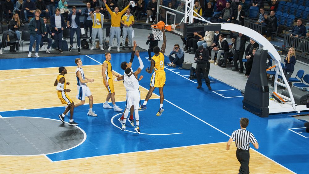 Black Basketballer Scores a Successful Dunk with One Hand