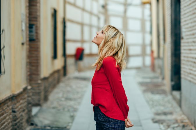 Happy young blond woman walking down the street