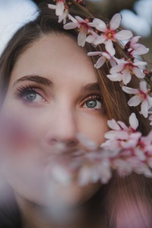 Young woman near tree twig with flowers