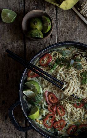Green curry noodles in pot on table