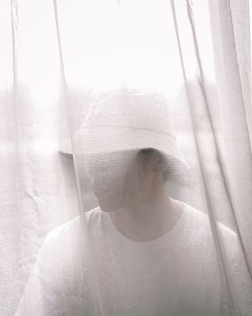 Portrait of young man behind light curtain