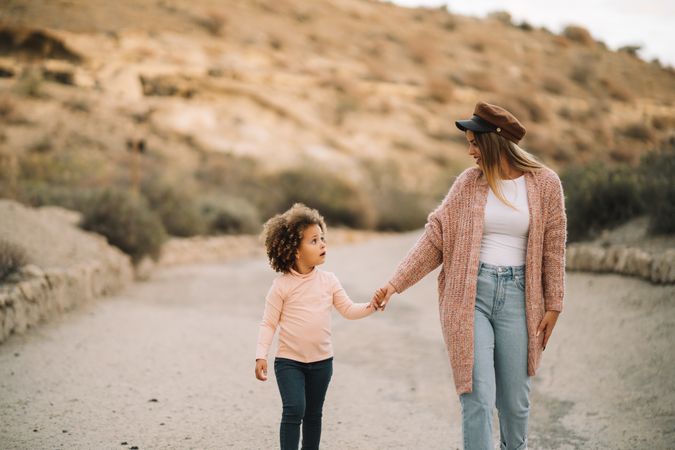 Mother walking with kid holding hands