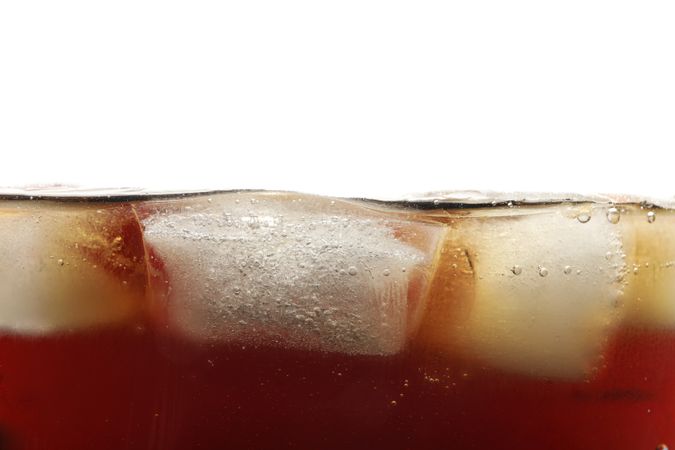 Side view background of cold cola with ice, isolated