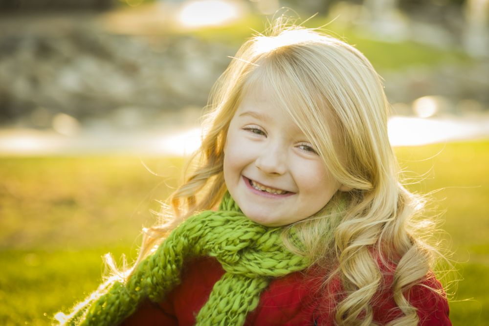 Little Girl Wearing Winter Coat and Scarf at the Park.