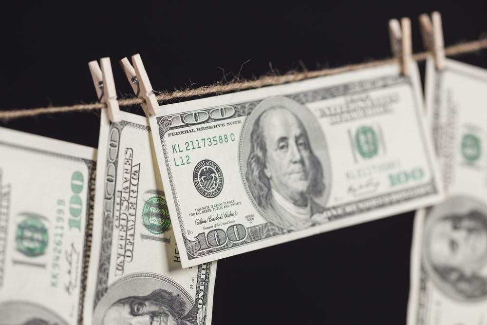 Hundred Dollar Bills Hanging From Clothesline on Dark Background