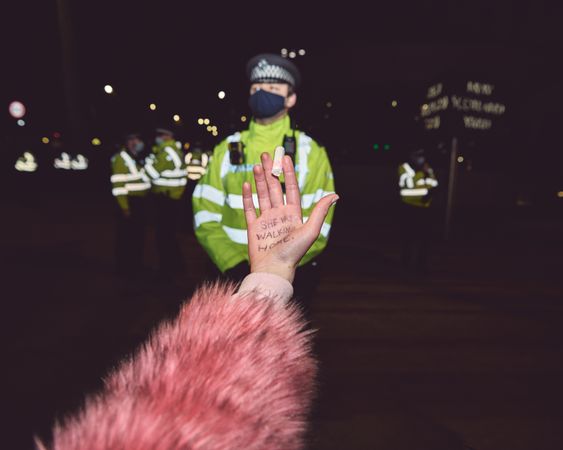 London, England, United Kingdom - March 16, 2021: Woman with tampon in hand in front of policemen
