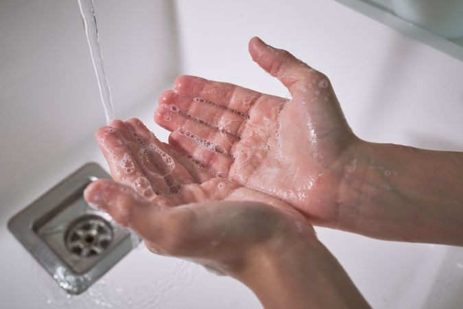 Anonymous kid washing hands with soap