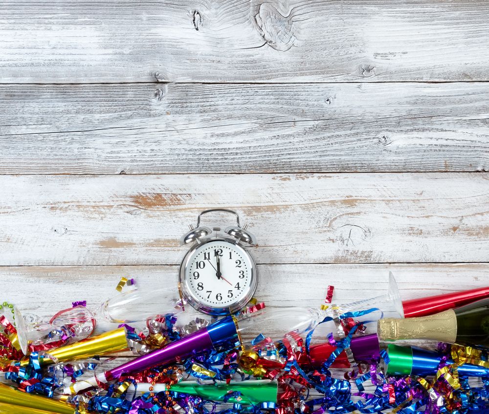 Happy New Year Celebration with party objects and clock on rustic wooden boards