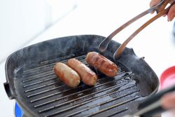 Cooking Process Making Grilled Sausages in the Kitchen