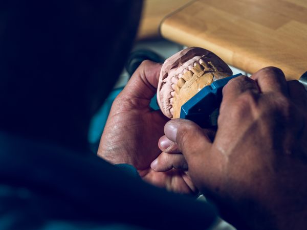 Faceless dental technician during work