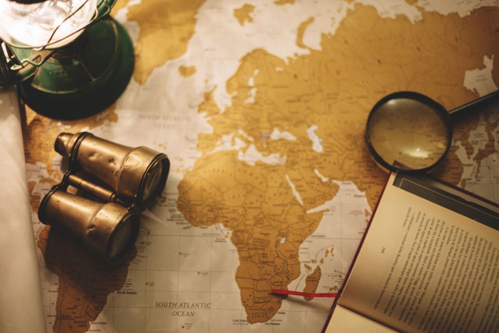 Binoculars and magnifying glass on paper map